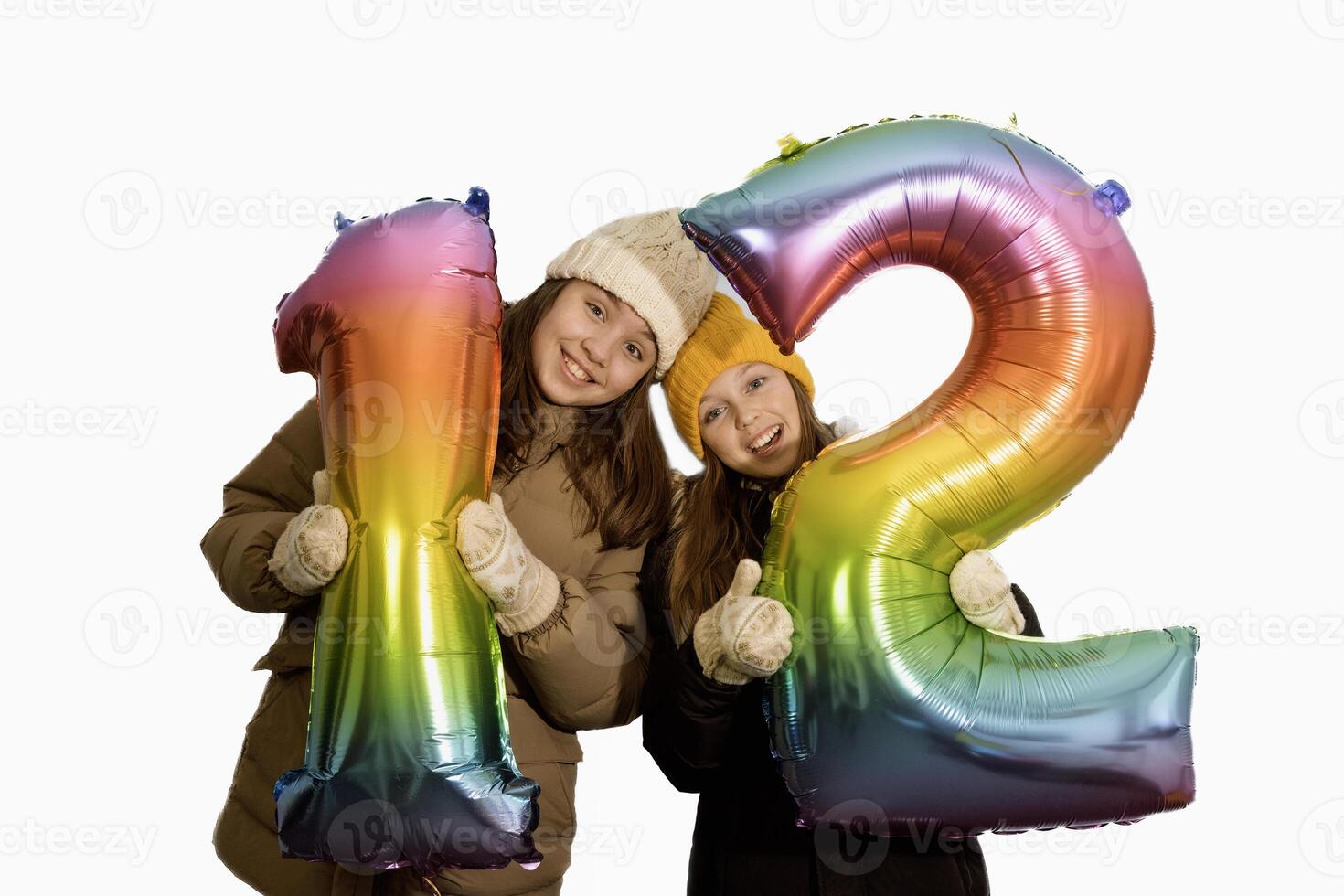 Girlfriends are holding large inflatable numbers 12 twelve. Girls 10-12 years old. card. white background photo
