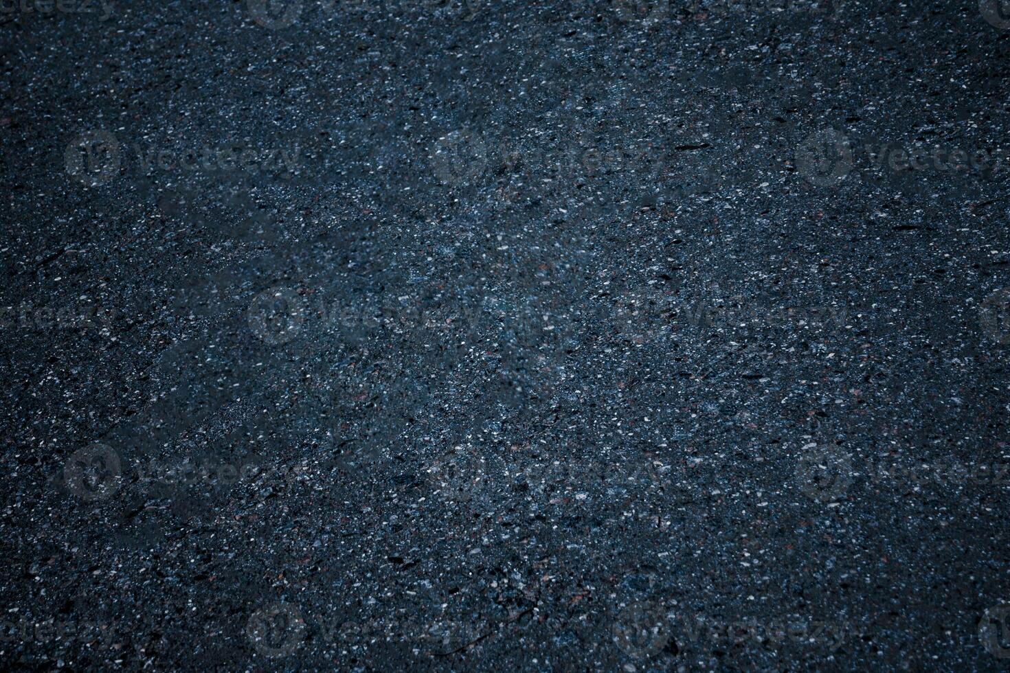 Top view on a dark gray asphalt surface as background, texture photo