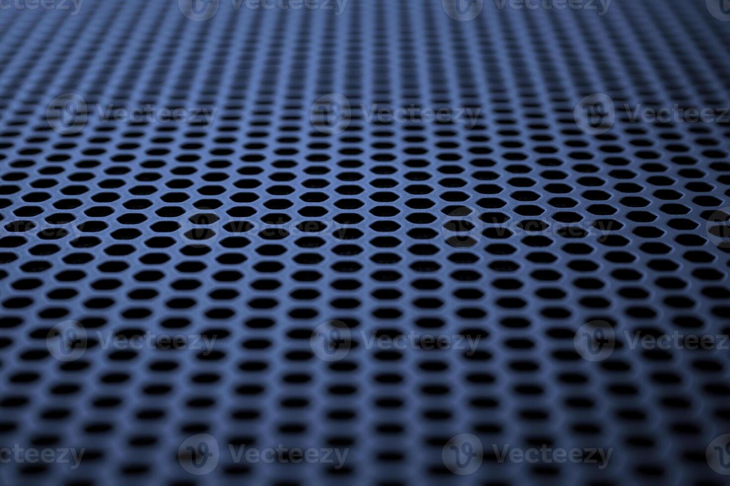 Industrial background. Deep blue metal surface with regular round holes photo