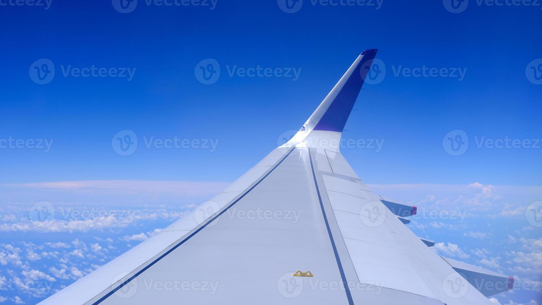 Horizontal air plane with gradient blue sky and white fluffy clouds photo
