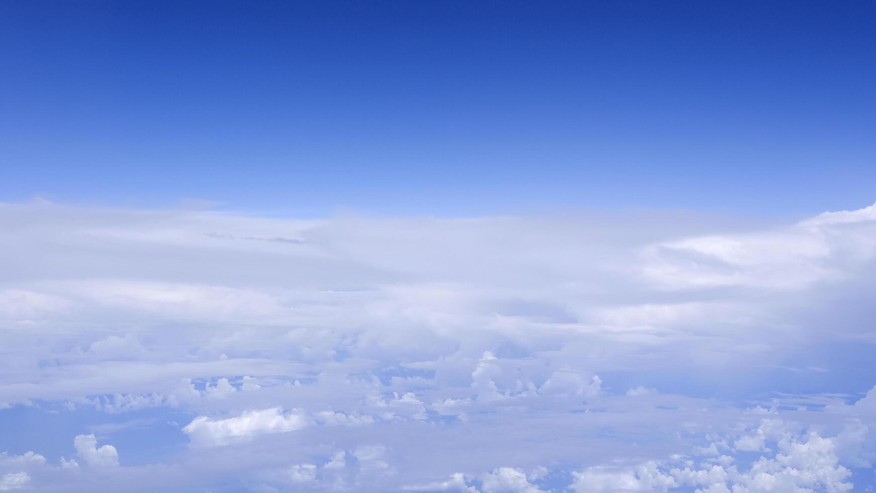 Horizontal gradient blue sky with white fluffy clouds photo