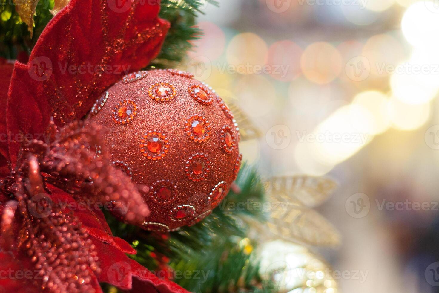 Close up view of a red ball decorated with rubies on a Christmas tree photo
