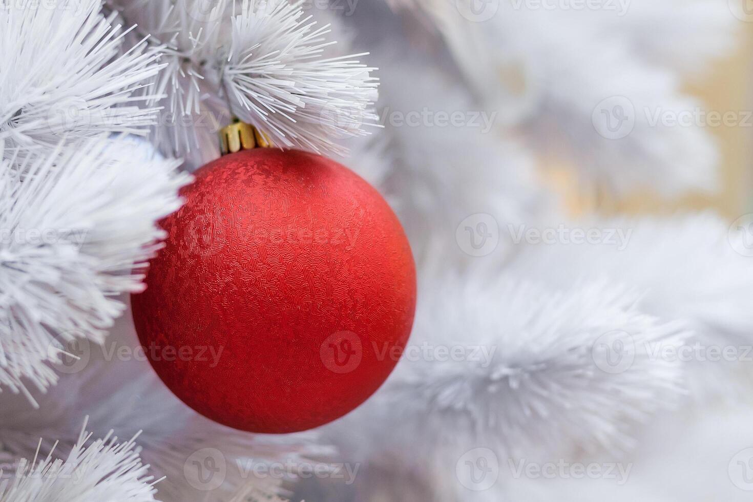 Close up view of a white artificial Christmas tree decorated with red balls photo