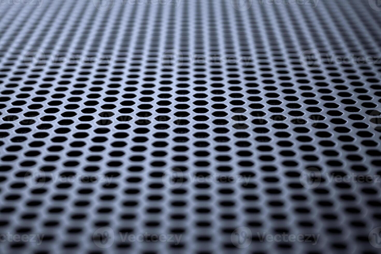 Metallic surface with regular round holes. Industrial background photo