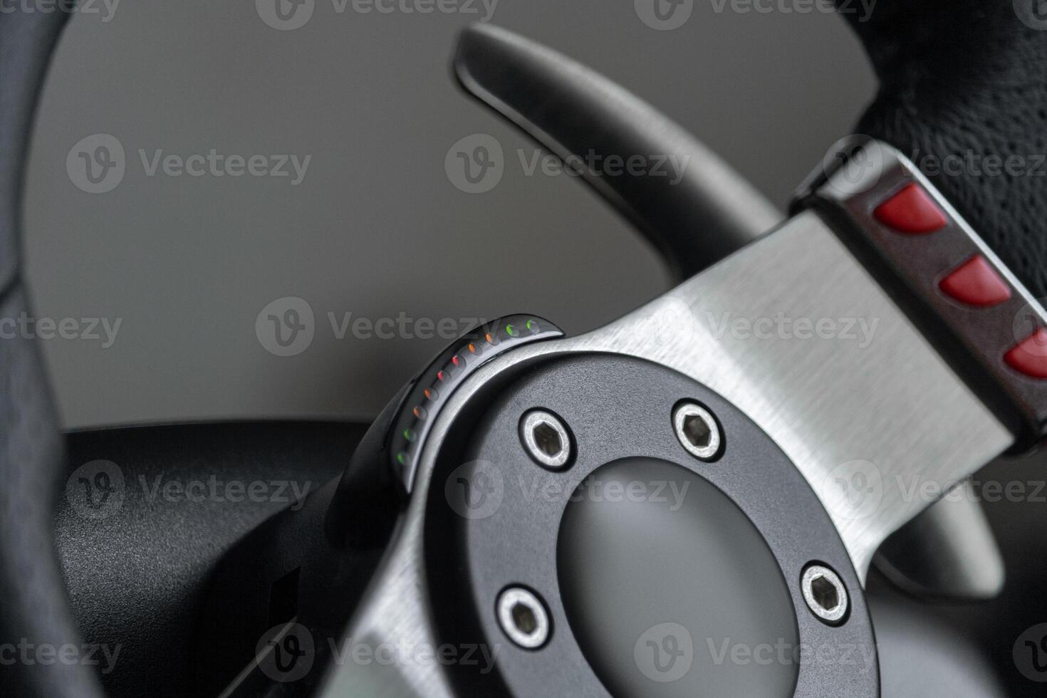 Close up view on a racing steering wheel with red buttons and metal gearshift paddles photo