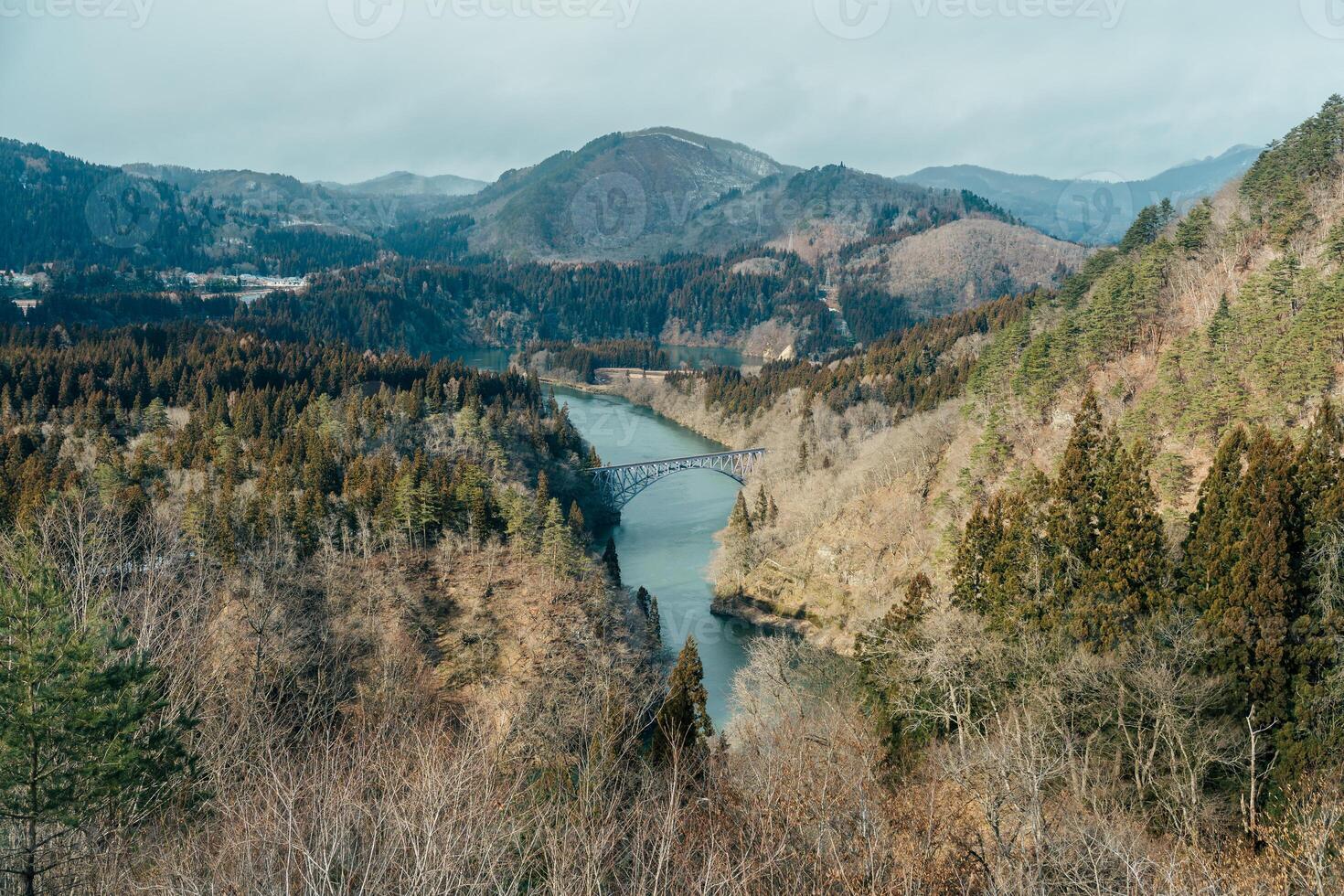 Panoramic View of Japan local train with Tadami river and bridge. Tadami Railway Line in The Valley at Mishima Machi, Aizu, Fukushima Prefecture, Japan. Landmark and iconic spot for tourist attraction photo