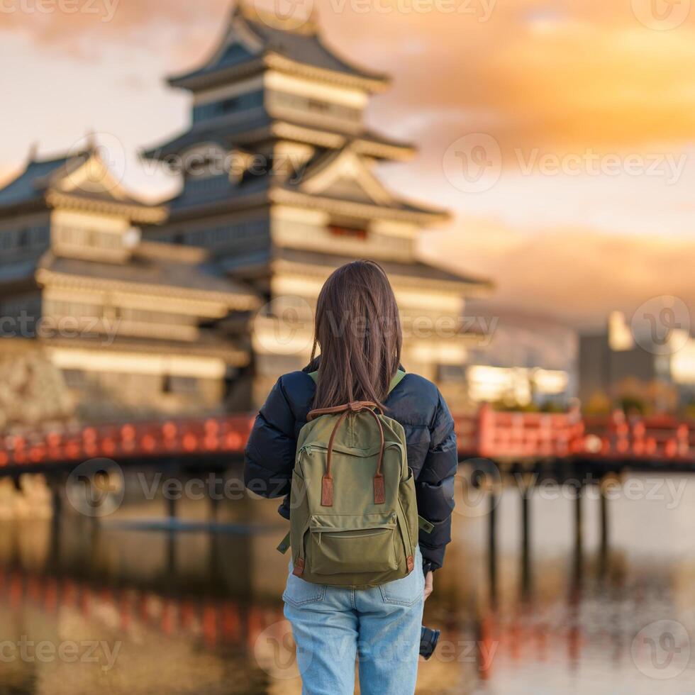 Woman tourist Visiting in Matsumoto, happy Traveler sightseeing Matsumoto Castle or Crow castle. Landmark and popular for tourists attraction in Matsumoto, Nagano, Japan. Travel and Vacation concept photo
