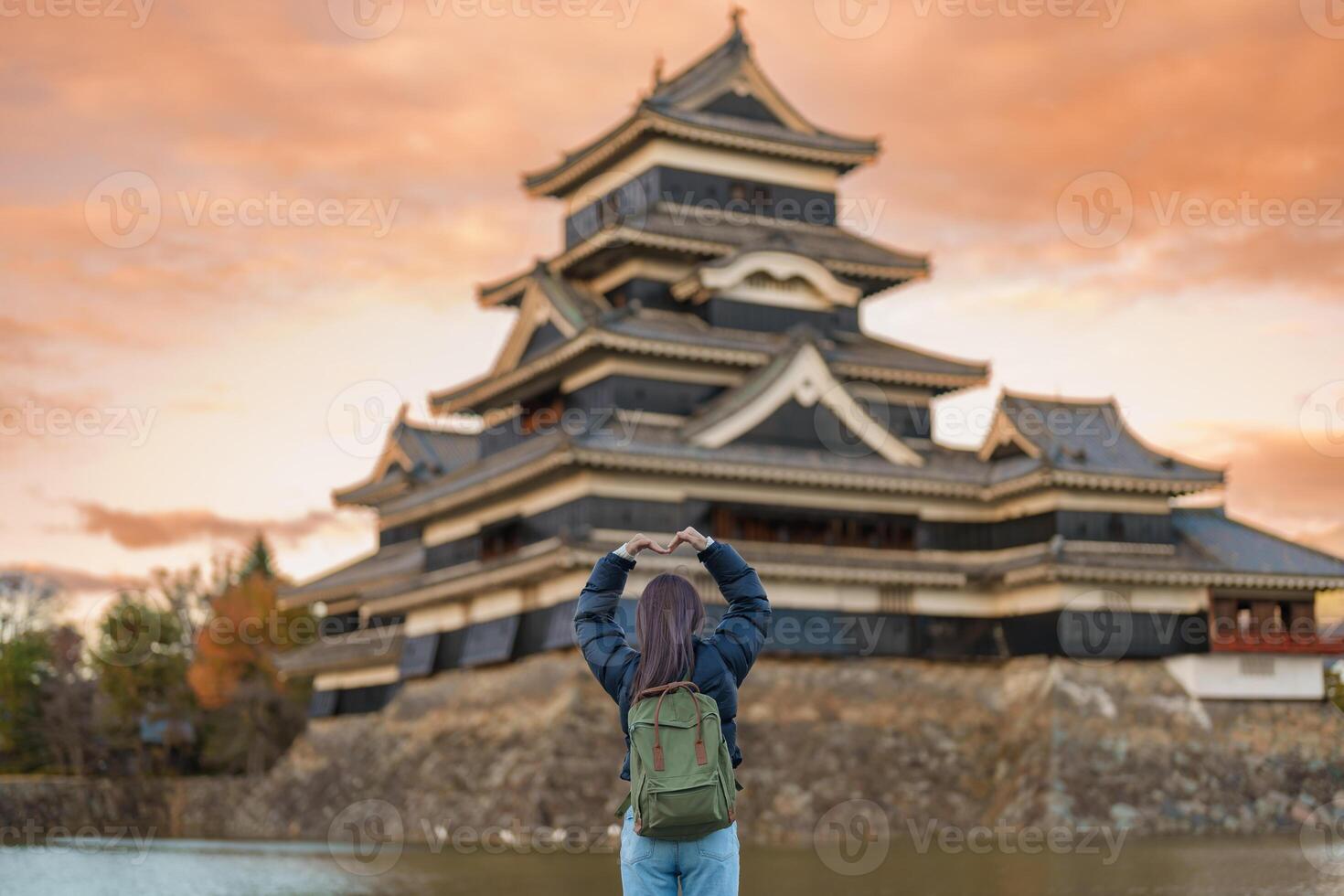Woman tourist Visiting in Matsumoto, happy Traveler sightseeing Matsumoto Castle or Crow castle. Landmark and popular for tourists attraction in Matsumoto, Nagano, Japan. Travel and Vacation concept photo