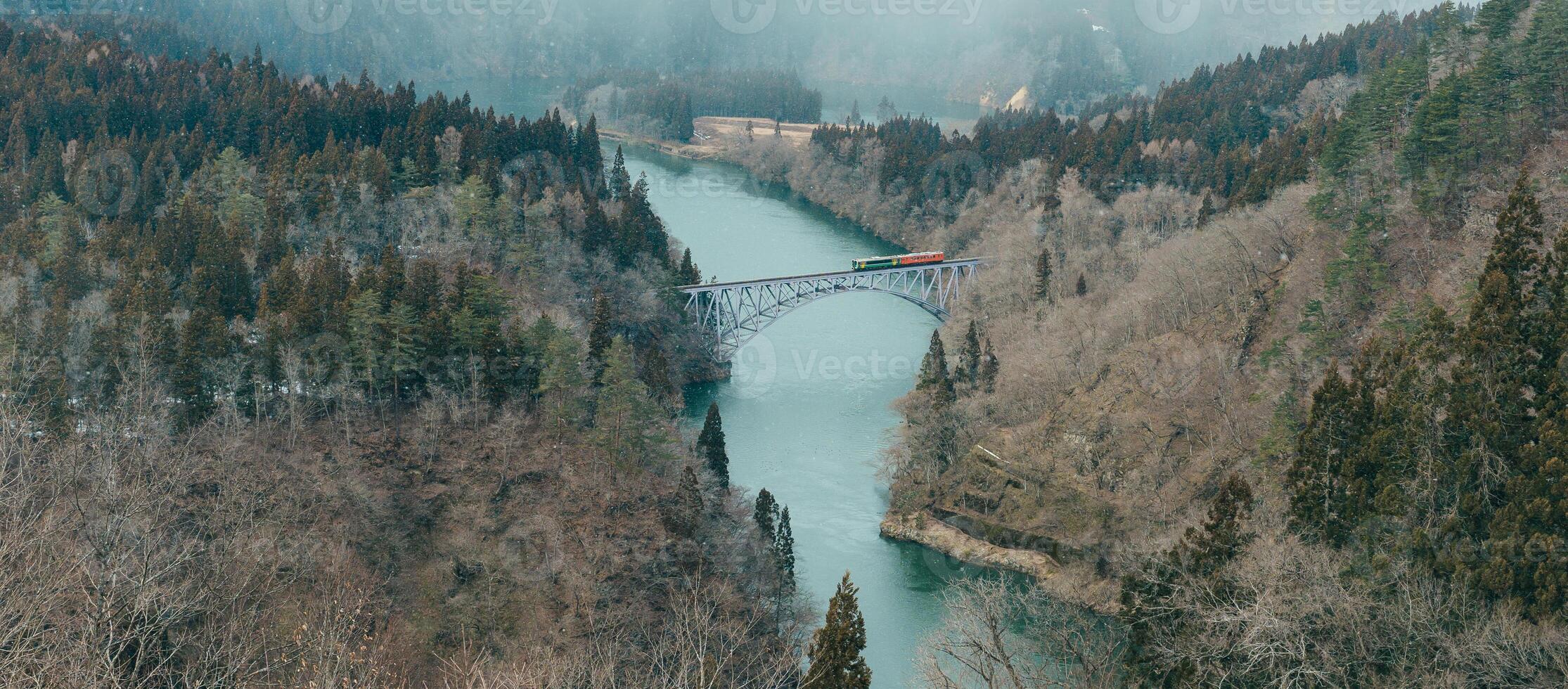 Panoramic View of Japan local train with Tadami river and bridge. Tadami Railway Line in The Valley at Mishima Machi, Aizu, Fukushima Prefecture, Japan. Landmark and iconic spot for tourist attraction photo