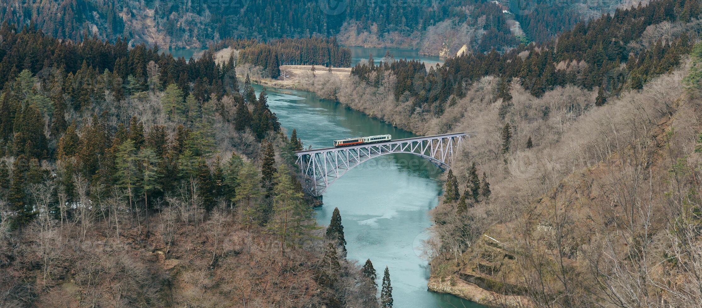Panoramic View of Japan local train with Tadami river and bridge. Tadami Railway Line in The Valley at Mishima Machi, Aizu, Fukushima Prefecture, Japan. Landmark and iconic spot for tourist attraction photo
