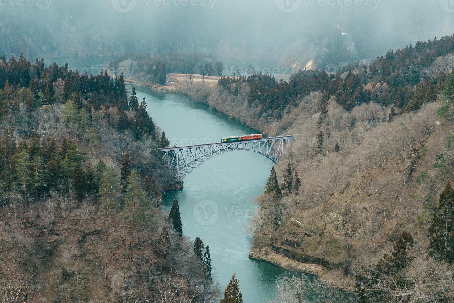 Panoramic View of Japan local train with Tadami river and bridge. Tadami Railway Line in The Valley at Mishima Machi, Aizu, Fukushima Prefecture, Japan. Landmark and iconic spot for tourist attraction photo