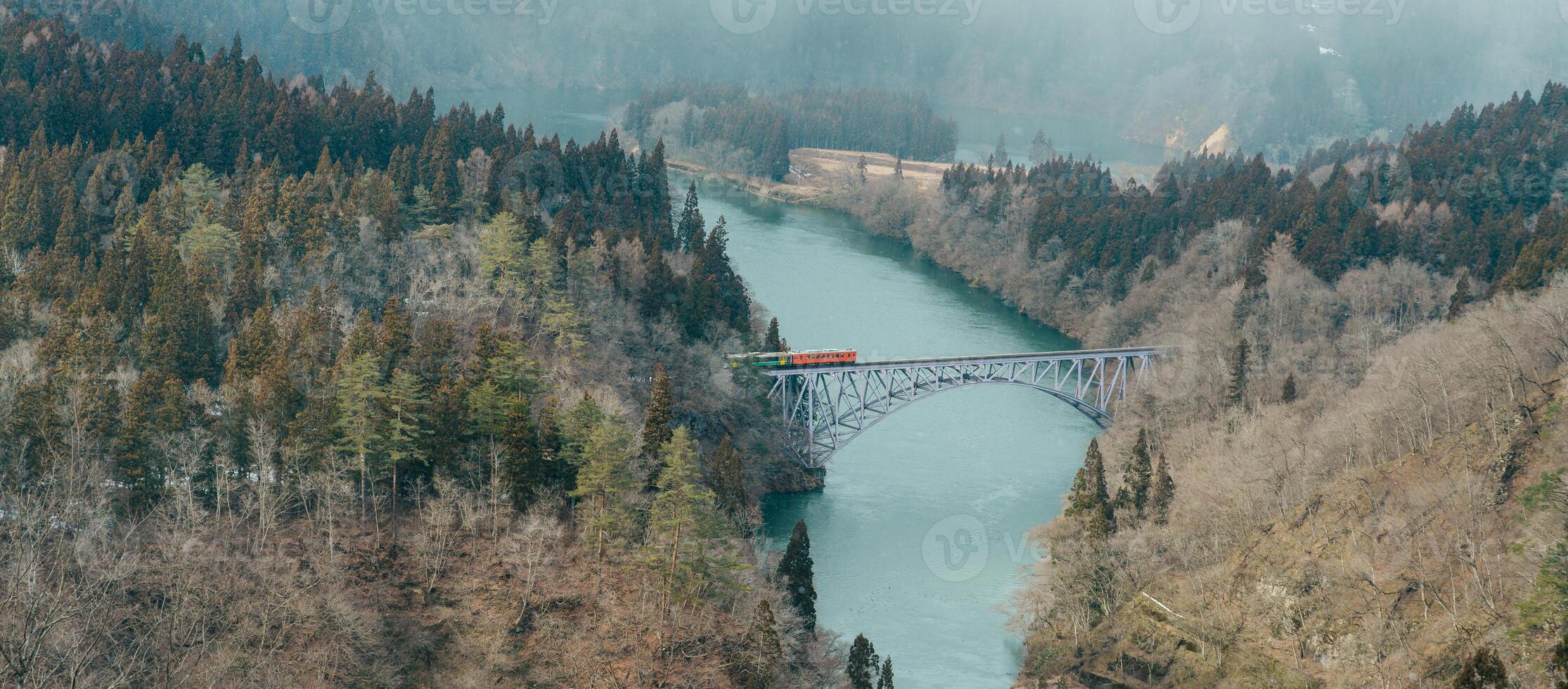 Panoramic View of Japan local train with Tadami river and bridge. Tadami Railway Line in The Valley at Mishima Machi, Aizu, Fukushima Prefecture, Japan. Landmark and iconic spot for tourist attraction photo