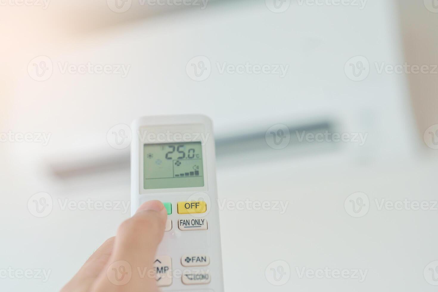 hand operating remote controller for adjust Air conditioner inside the room of office or house photo