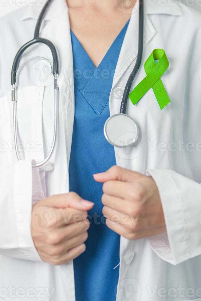 Doctor with green Ribbon for world Lymphoma Awareness September month, world Mental Health Day, Liver, Gallbladders, bile duct, cervical, kidney Cancer. Healthcare and world cancer day concept photo