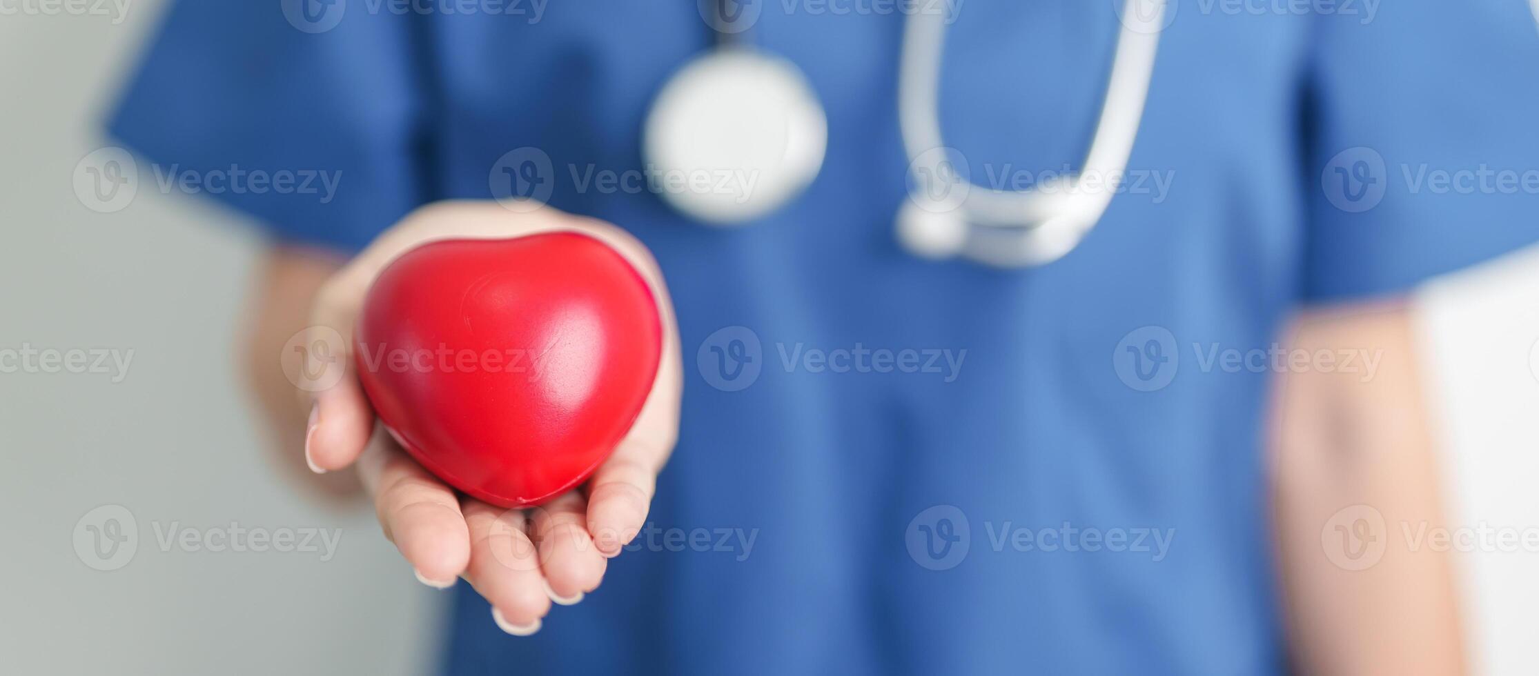 Doctor hand holding red heart shape in hospital. love, donor, world heart day, world health day, CSR donation and Insurance concepts photo