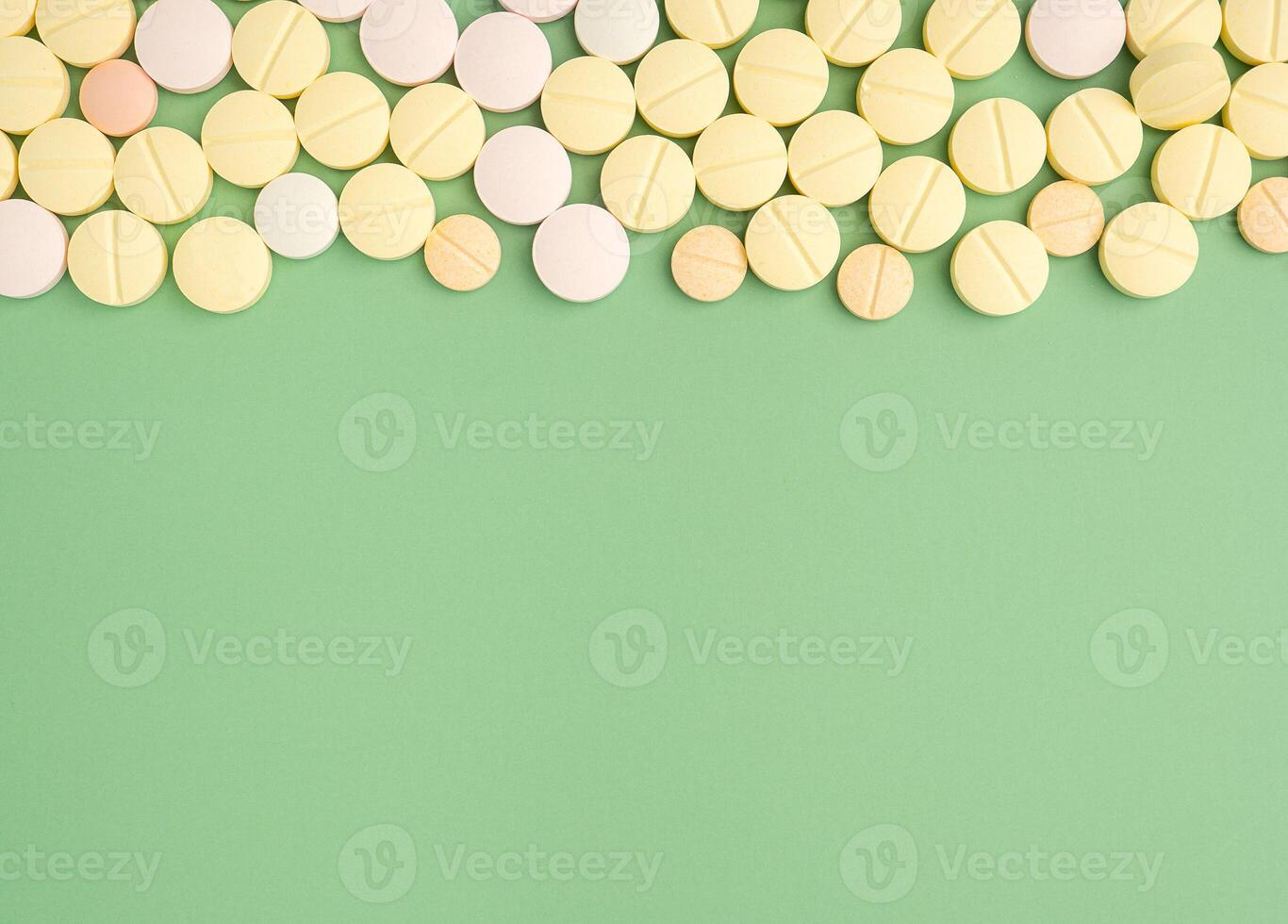 Pile of tablets medicine for people's health to heal diseases isolated on a green background. Space for text. Top view. Healthcare and medical concept photo