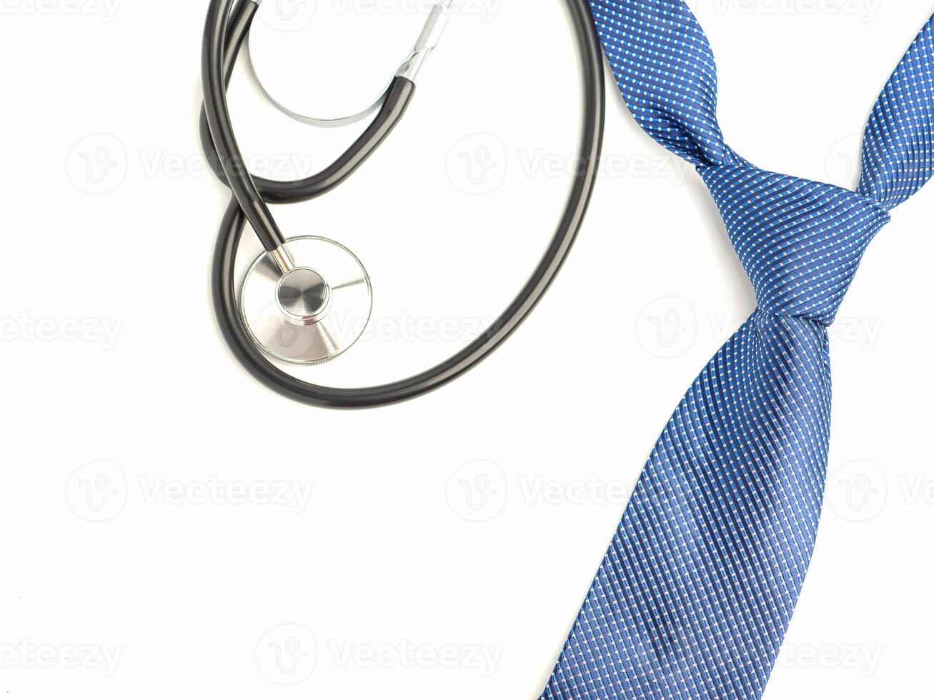 A stethoscope and blue tie laid isolated on a white background. Top view. Flat lay with space for text photo