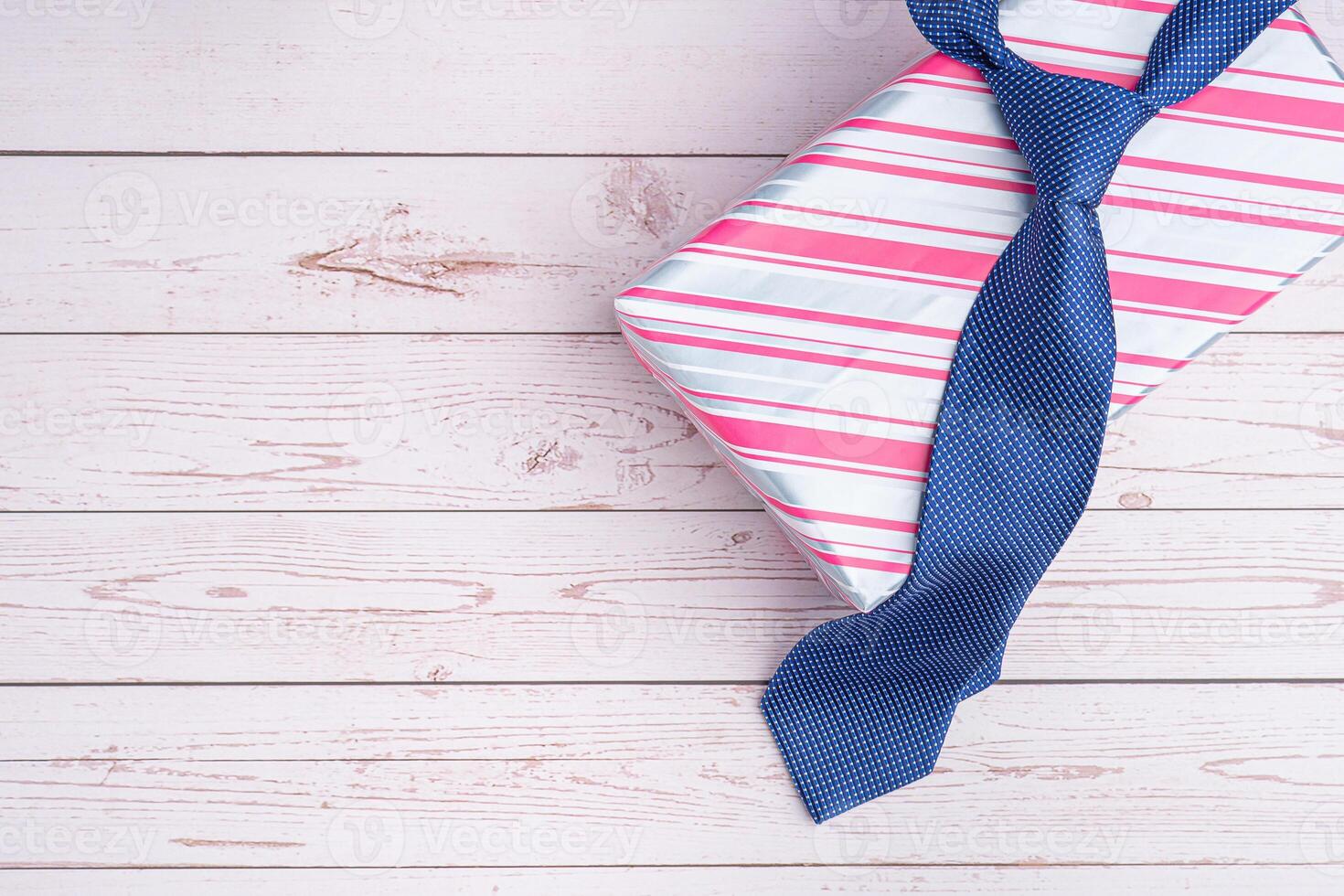 Happy Father's Day with a blue tie and a gift box on wooden background with space for text. Top view. Flat lay photo