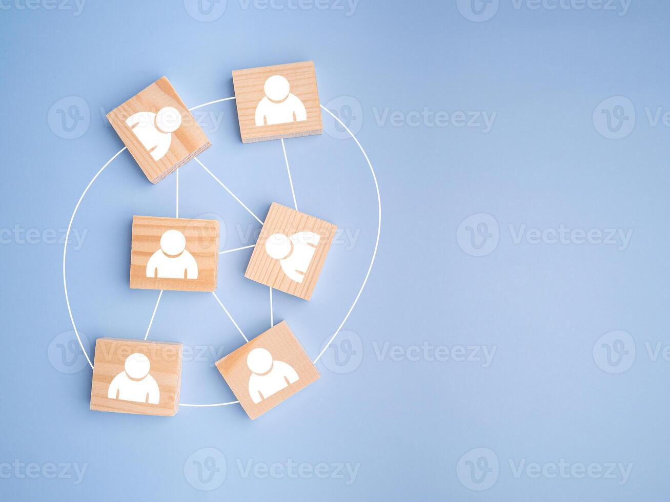 Top view of wooden blocks with white human icons scattered on a light blue background photo