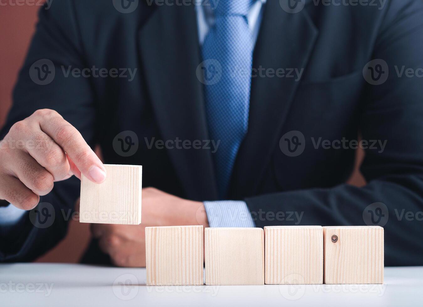 Hand of businessman arranging empty wooden blocks. Close-up photo. Space for text. Business and strategy planning concept photo
