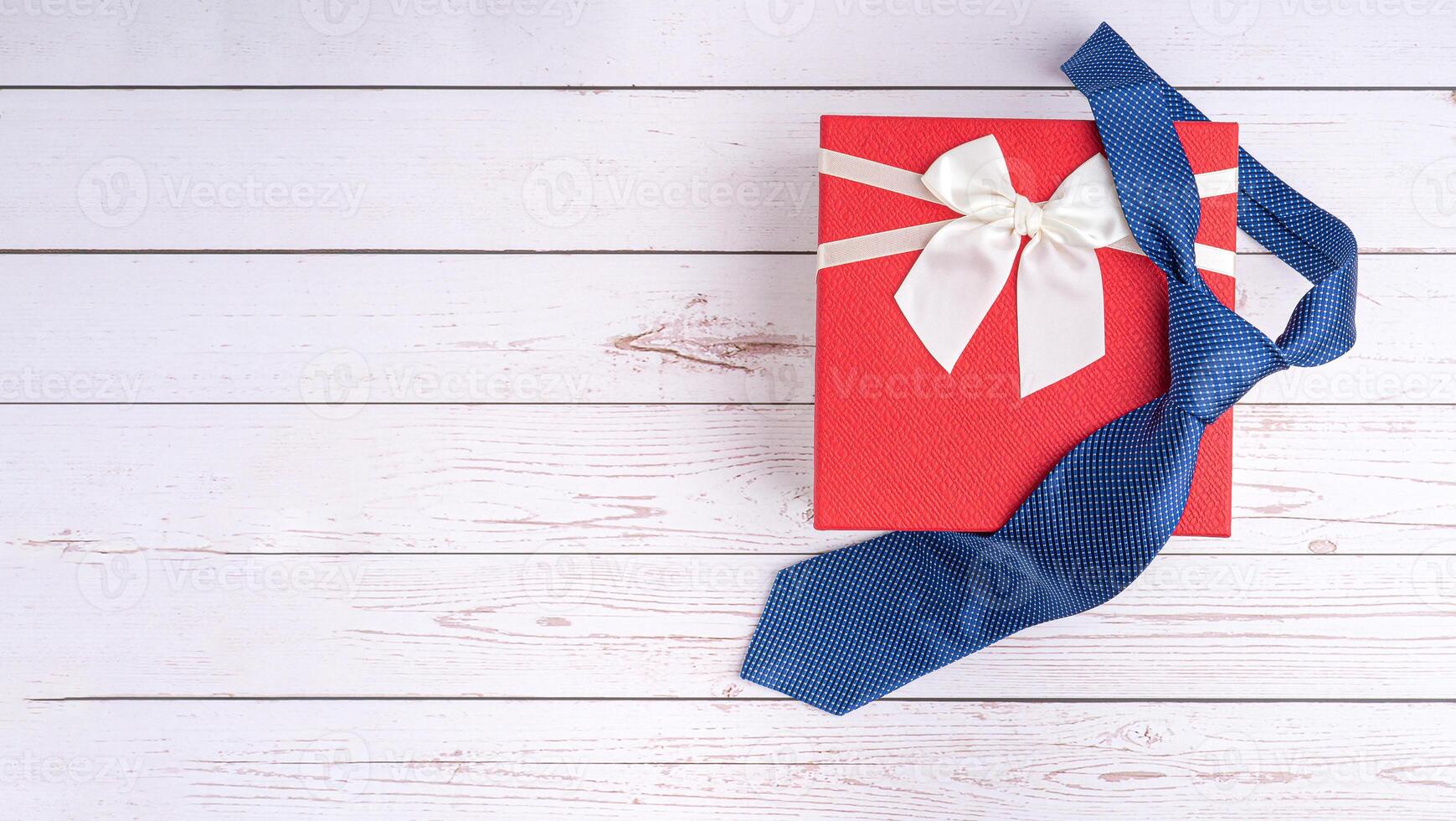 Happy Father's Day with a blue tie and a gift box on wooden background with space for text. Top view. Flat lay photo