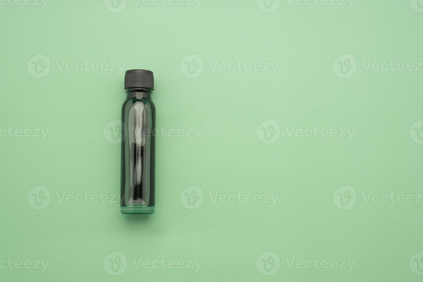 Essential oils in a bottle placed on a green background. Space for text. Top view photo