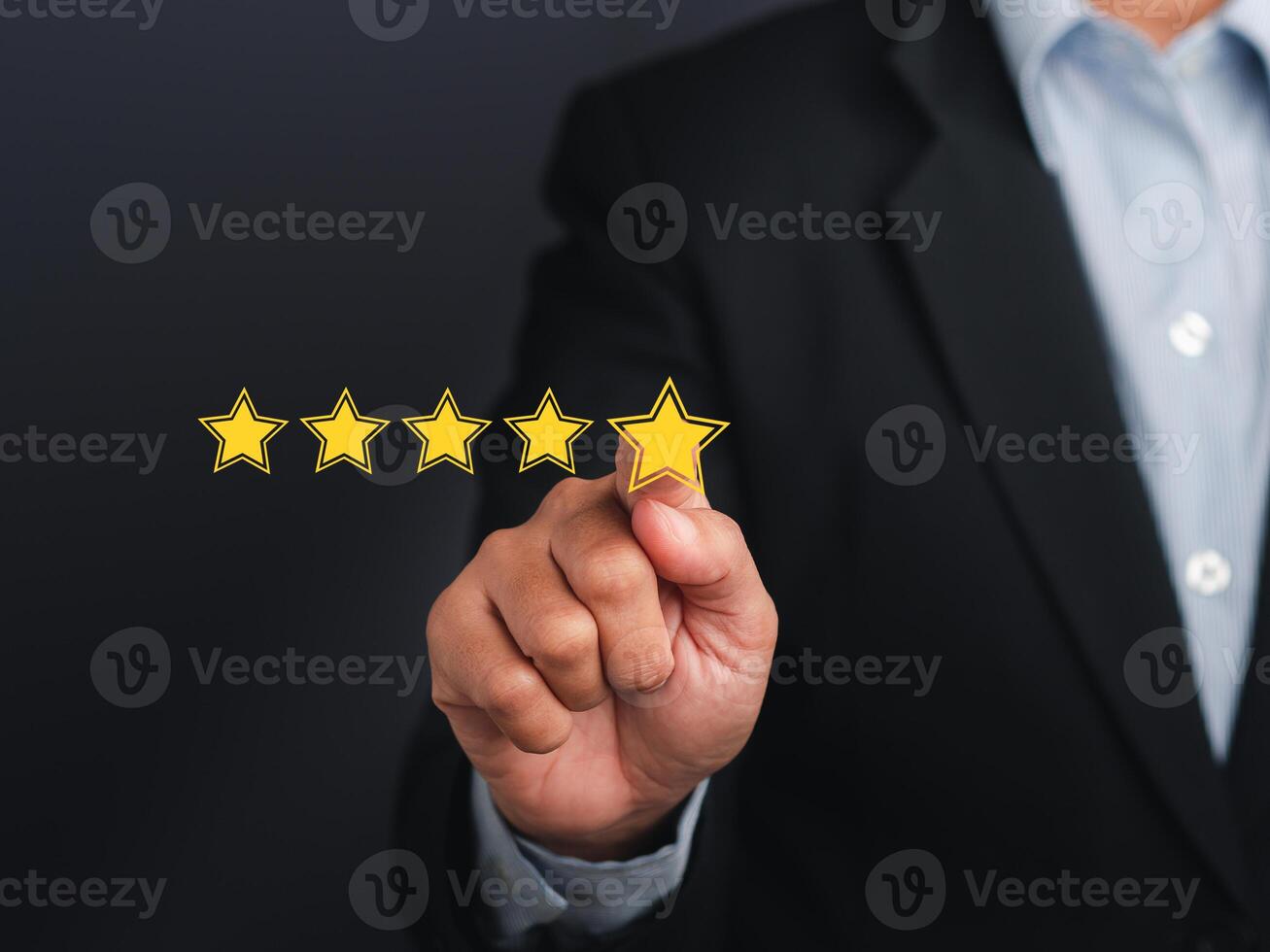 Businessman pointing five-star symbol to increase the rating of the business against a gray background. Customer feedback and experience concept photo