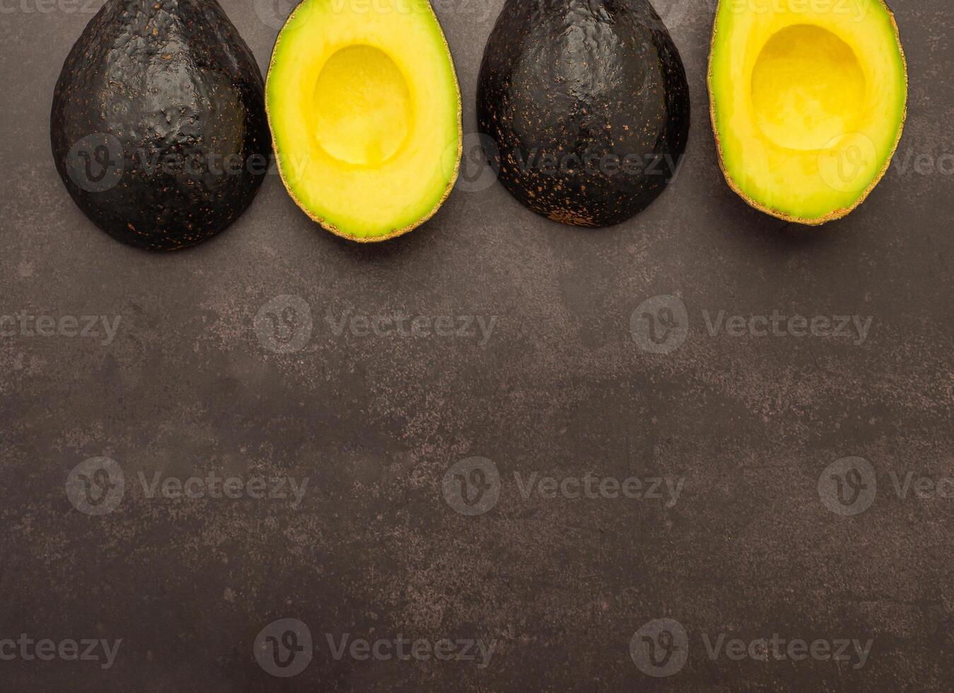 Top view of fresh avocado half on the old kitchen table. Organic fruit. Space for text. Concept of healthy fruits and healthcare photo