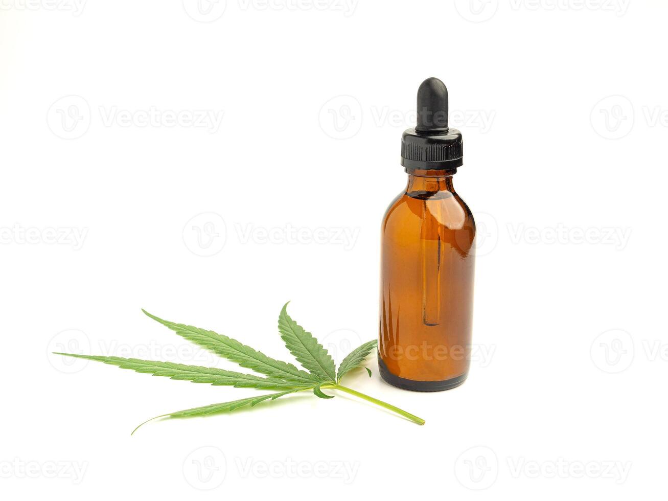 A bottle of cannabis oil extracts and green marijuana leaves isolated on a white background. Medical cannabis concept photo