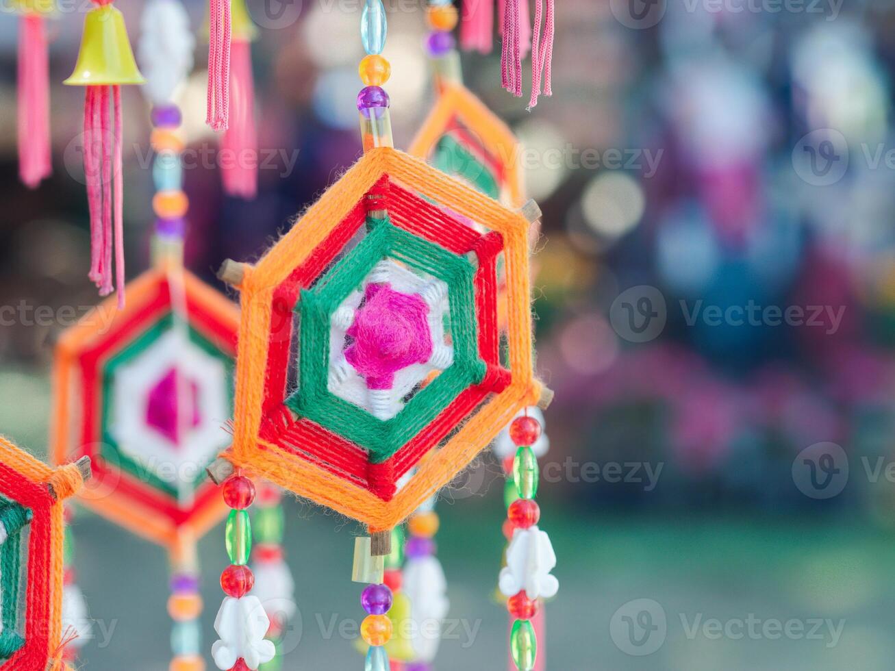 Colorful decorative mobile spider web weaving hanging on a tree. Crafting colorful yarn to use decorations for festivals. Space for text photo
