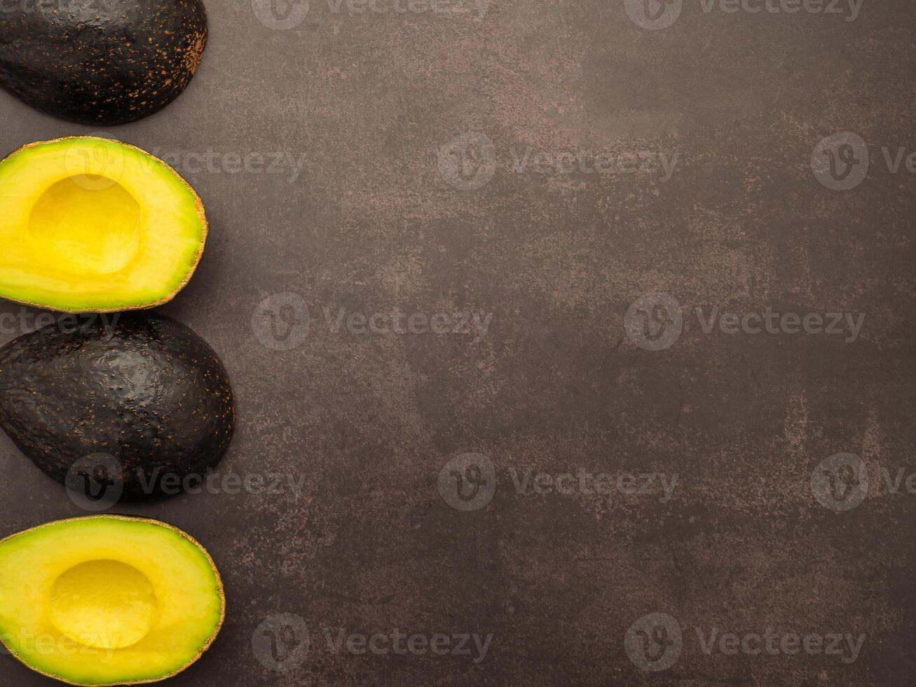 Top view of fresh avocado half on the old kitchen table. Organic fruit. Space for text. Concept of healthy fruits and healthcare photo
