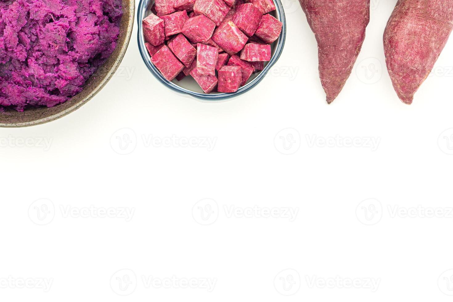 Purple yams whole, sliced square in a bowl, and mashed potatoes on the dish placed on a white background. Space for text. Purple sweet potatoes. Top view. Vegan fruit and healthy fruits concept photo