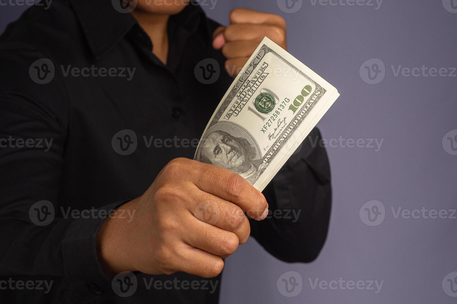 Businessman hand holding of US banknotes and a fist while standing in a studio. Close-up photo. Business and finance concept photo