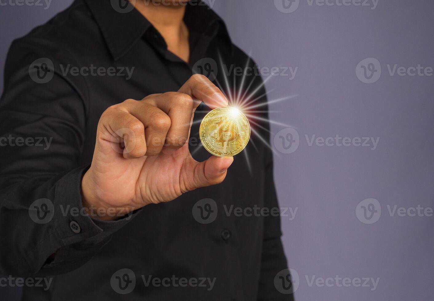 Investor guy showing a bitcoin golden coin with effect sunlight. Close-up photo. Space for text. Virtual cryptocurrency and future money concept photo
