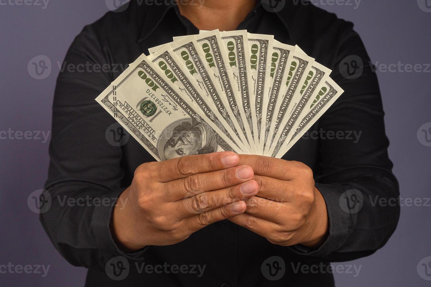 Businessman hand holding of US banknotes while standing in a studio. Close-up photo. Business and finance concept photo