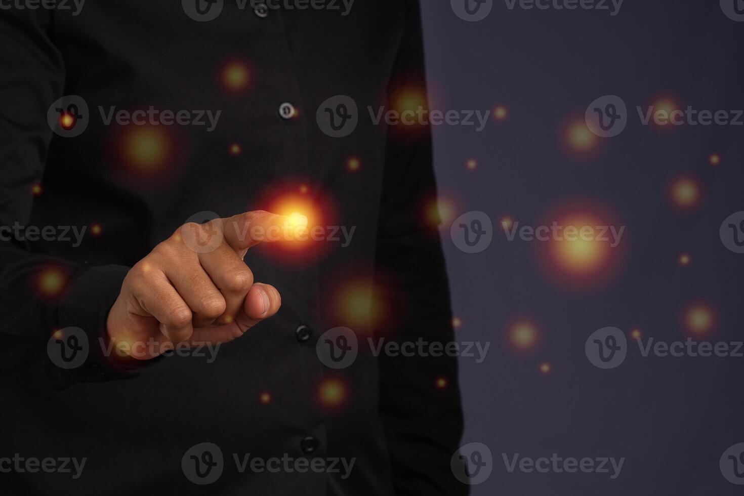 Close-up of finger touching circle light orange while standing in the studio with a black background. Business concept photo