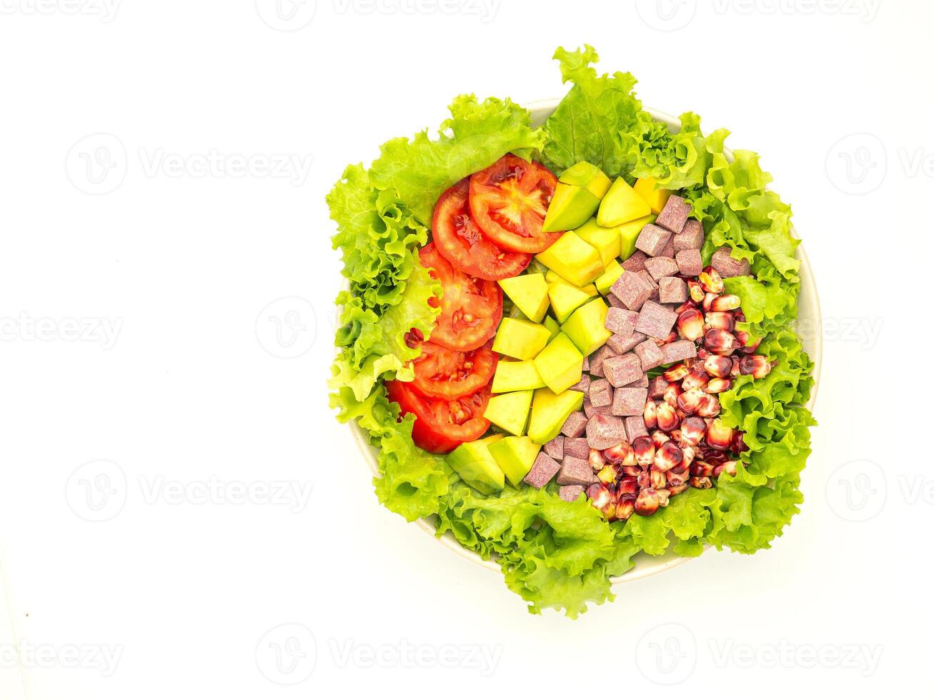 Top view of green lettuce salad with fresh mixed purple corn, purple yams, avocado, and tomatoes on a dish placed on white background. Space for text. Healthy foods concept. Clipping path photo
