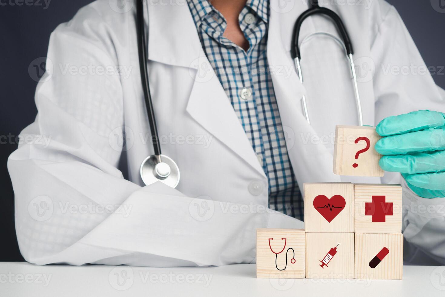 A doctor hand holding wooden blocks with icons of health while sitting on a chair in the hospital. Close-up photo. Space for text. Concept of doctor work in maintaining human health photo