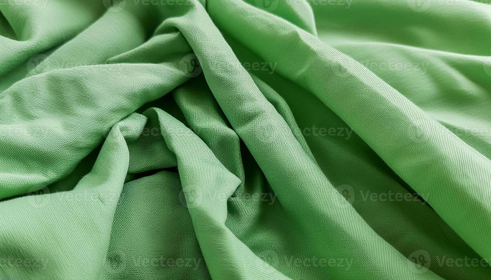 Texture of crumpled fine green cotton fabric as background. Shabby bed sheets. top view.pattern texture background photo