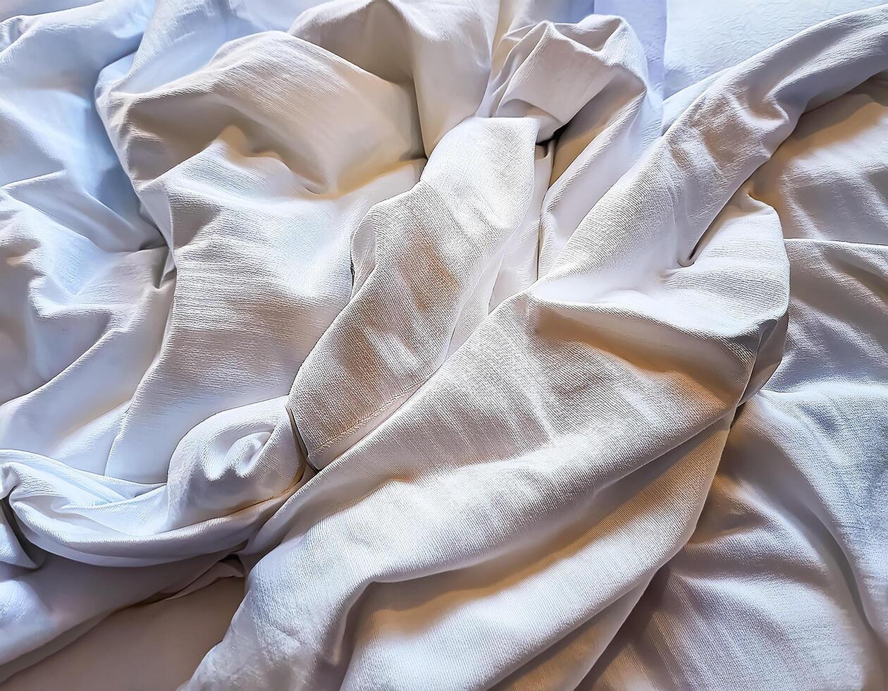 Background concept. Soft bed sheets that are still wrinkled after being used. The white bed sheets were crumpled and shabby. Pattern texture background. photo