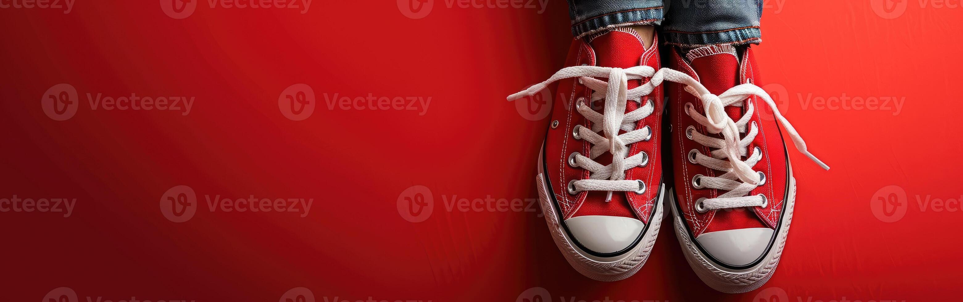 Red Sneakers Hanging on Red Wall photo