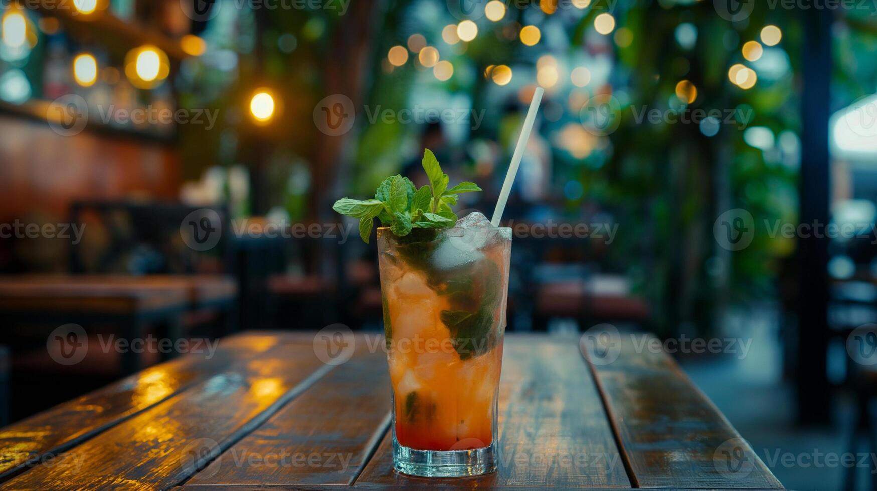Multicolored bright cocktail with straw in a glass close up with ice cube and mint photo