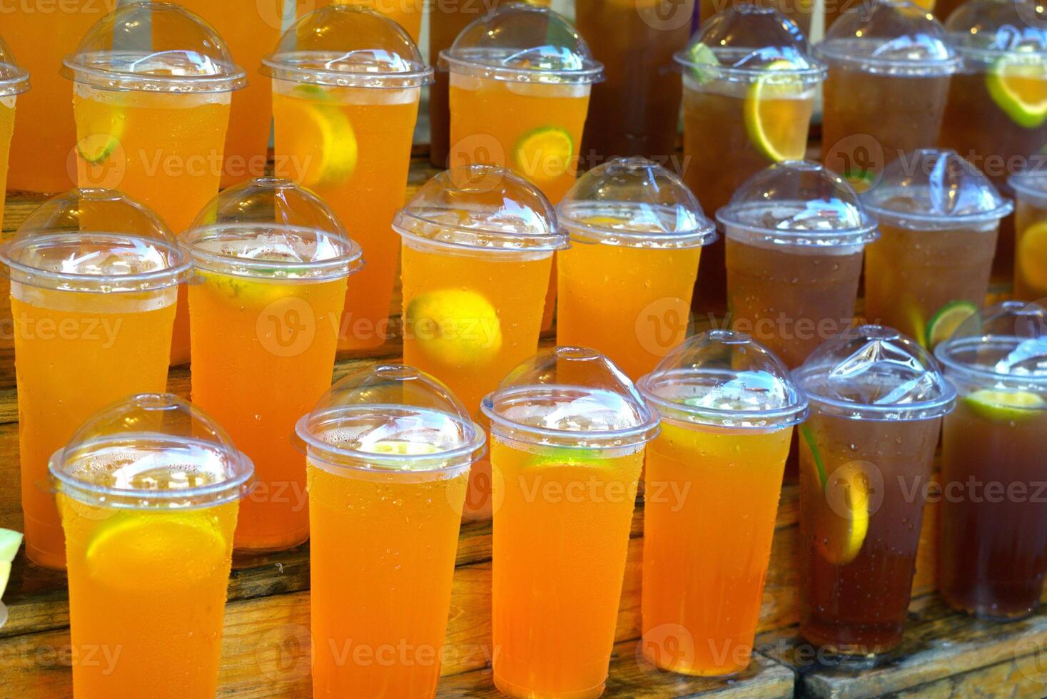 A group of orange juice and lemon tea on a market display photo