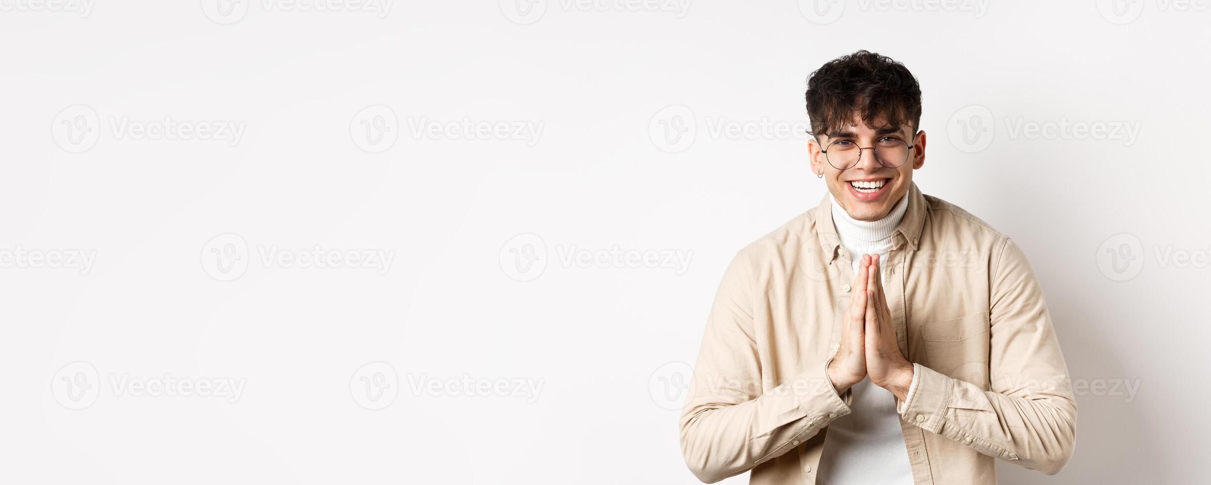 Handsome caucasian man say thank you, bowing with namaste gesture, looking grateful and smiling at camera, standing on white background photo