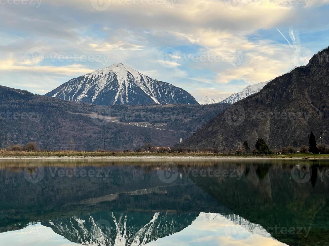 Mirror reflection of a snow-covered mountain in a lake with mountain water in Martigny, Switzerland photo