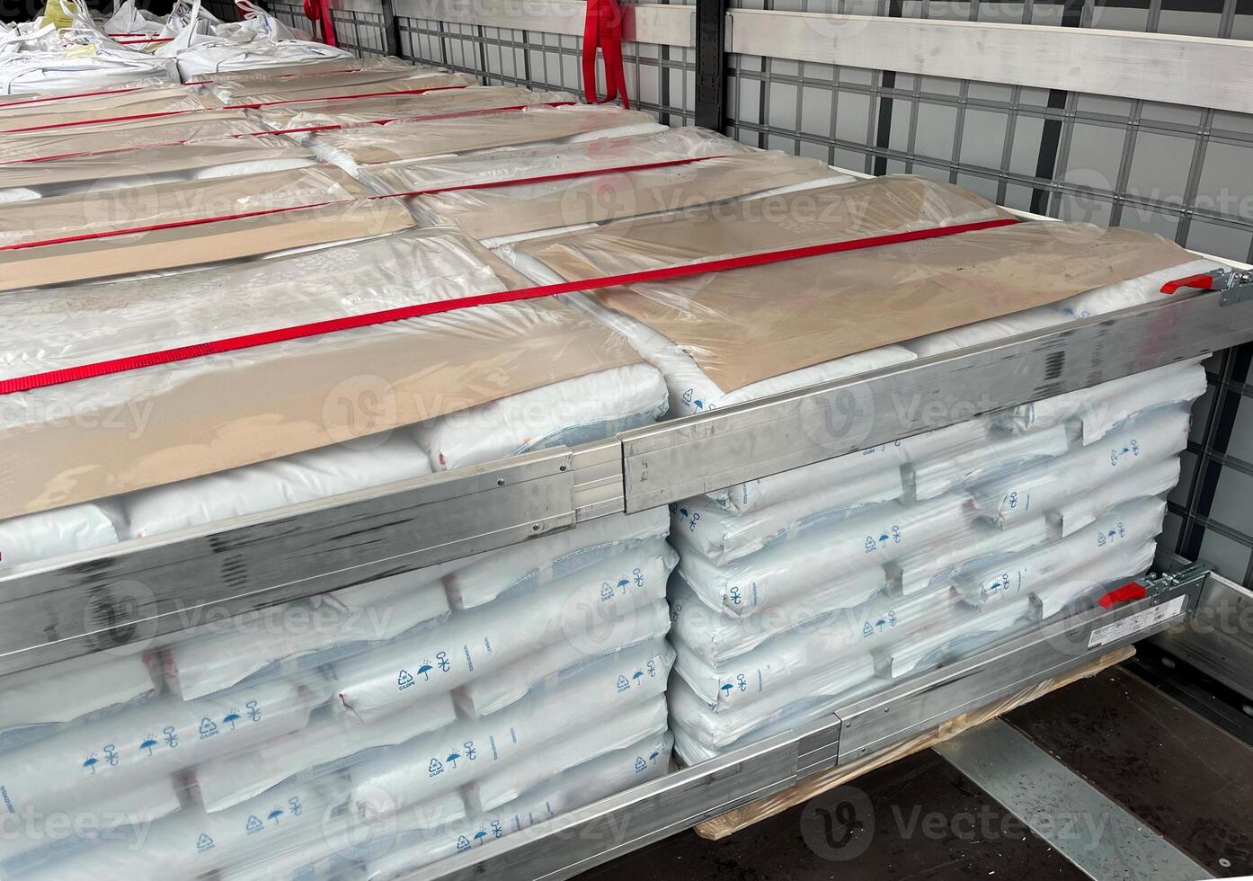 Loading, transportation and unloading of bulk materials in bags of 25 kilograms in a semi-trailer. Securing the cargo with straps and locks for stability photo