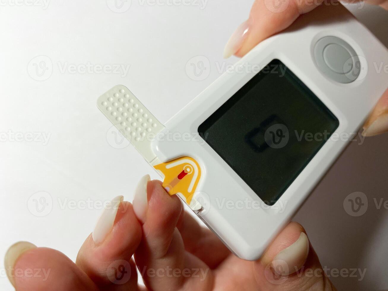 Measurement of blood sugar levels using a glucose meter with a mock-up. Piercing a finger to draw blood photo