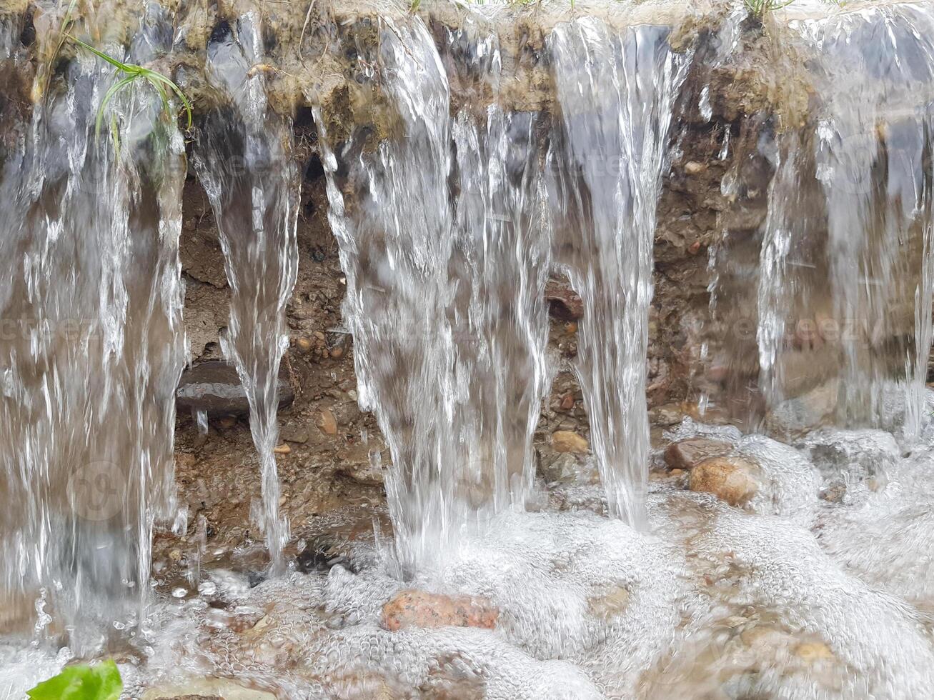 A small waterfall. Flowing water erodes the soil photo