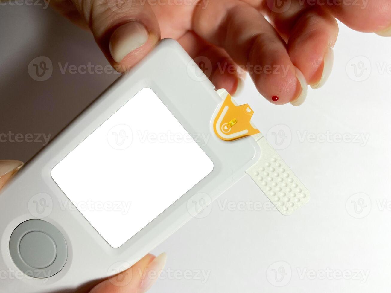 Measurement of blood sugar levels using a glucose meter with a mock-up. Piercing a finger to draw blood photo