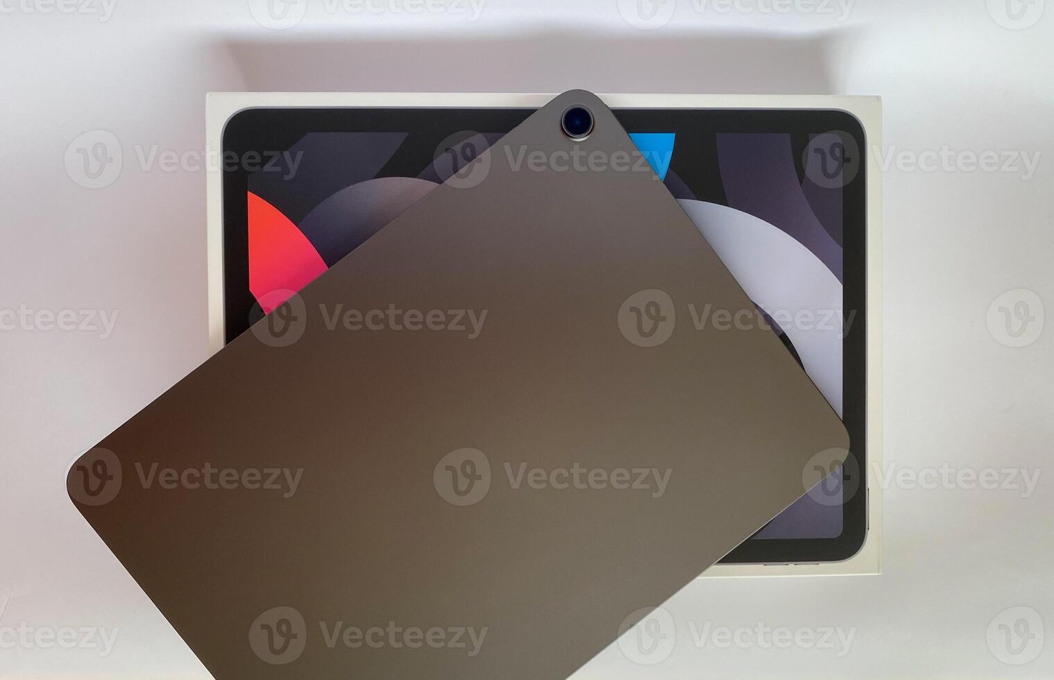The tablet is black on a white isolated background with a mock up. Back side view of the tablet photo